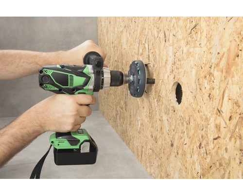 En person borrar ett hål i en träskiva med en sladdlös skruvdragare.