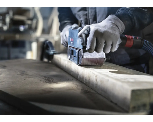 Hantverkare slipar trä med en bandslipmaskin