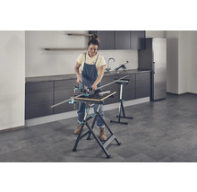 Kvinna arbetar med en arbetsbänk och en geringslåda i ett rum.