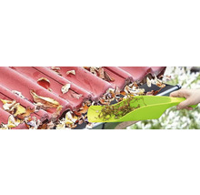 Rengöring av en takränna med en spade för att ta bort löv