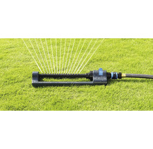 Grässpridare i drift på en gräsmatta