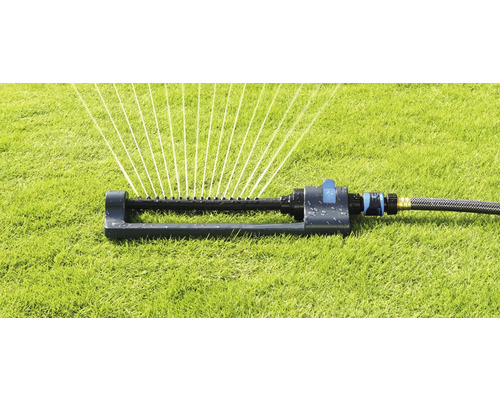 Grässpridare i drift på en gräsmatta