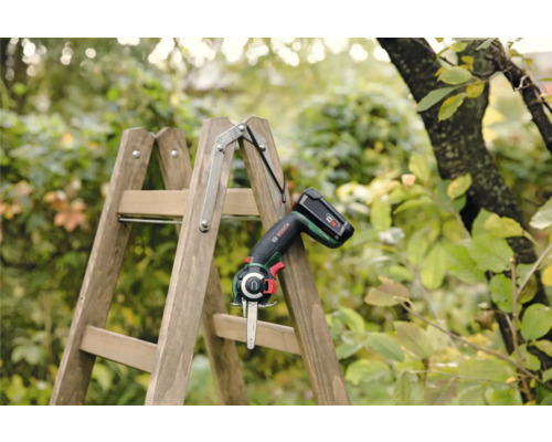 Batteridriven trädgårdssåg på trästege i trädgården