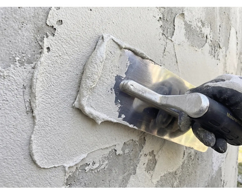 Applicering av puts med spackel på en vägg