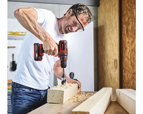 Man borrar ett hål i en träbit med en sladdlös skruvdragare