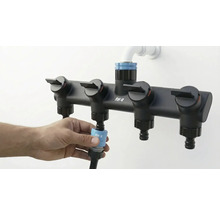 Vattenfördelare med fyra utgångar för trädgårdsbevattning ansluts till en trädgårdsslang