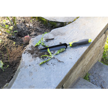 Trädgårdsredskap och ogräs på stentrappor