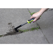 En hand använder en fogskrapa för att ta bort ogräs mellan gatstenar.