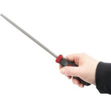 En hand håller en nyckelfil med plasthandtag.