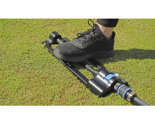 Trädgårdsspridare med fotpedal på gräsmatta