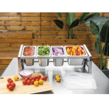 Ingrediensstation i rostfritt stål med fyra Gastronorm-kantiner fyllda med grönsaker och sås på ett metallbord med skärbräda.