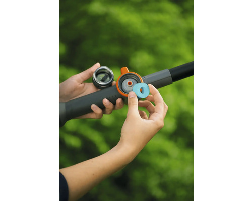 Insättning av en rengöringstablett i facket på en bevattningsstav för trädgården.