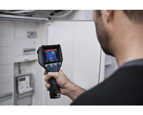 En person kontrollerar en elinstallation i ett fördelarskåp med en Bosch värmekamera.