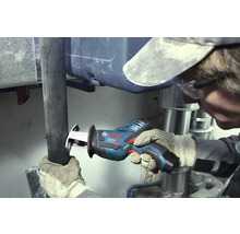 Hantverkare skär ett mörkt rör med en Bosch Professional sladdlös tigersåg i ett arbetsområde med silverfärgade metallrör.