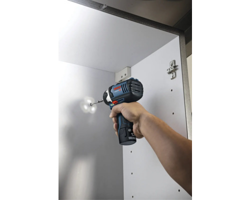Bosch batteridriven slagskruvdragare skruvar i en skruv i ett vitt skåp.
