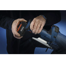 En person sätter i ett batteri från Bosch Professional 18 volt-systemet i en sticksåg.