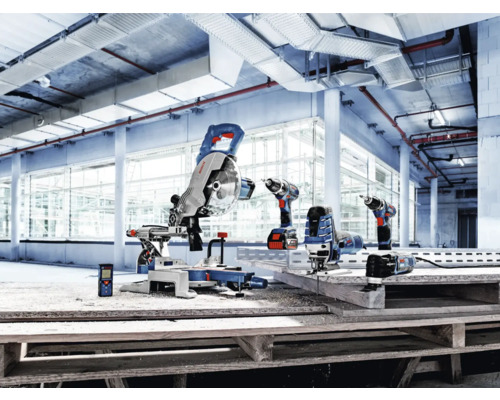 Urval av Bosch Professional elverktyg, inklusive kap- och gersåg, skruvdragare och sticksåg, i en ljus industrihall.