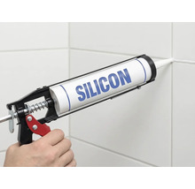 Applicering av silikon med en fogpistol på en kakelfog.