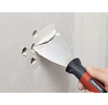 RAUTNER spackelspade fyller hål i en vägg med spackel.