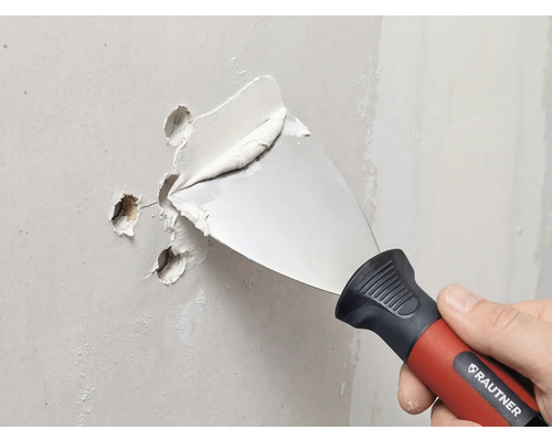 RAUTNER spackelspade fyller hål i en vägg med spackel.
