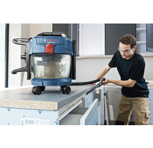 Bosch batteridriven våt- och torrdammsugare som används för att rengöra en arbetsbänk i en ljus verkstad.