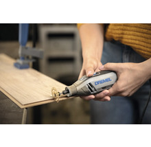 Dremel 4250 multiverktyg med kapskiva som skär i en träplanka.