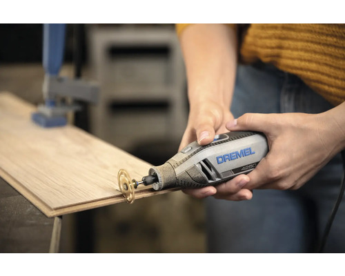 Dremel 4250 multiverktyg med kapskiva som skär i en träplanka.