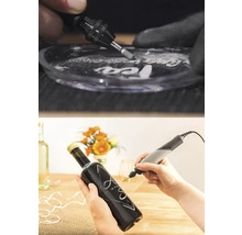 Dremel multiverktyg vid gravering av glas och en mörk glasflaska.