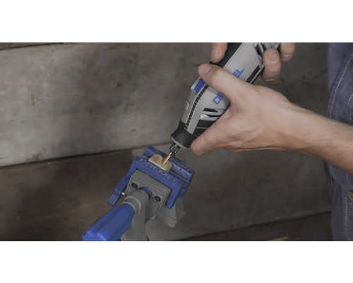 Användning av ett Dremel multiverktyg på en träbit fixerad i ett Dremel skruvstycke.