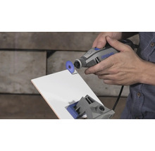 Dremel multiverktyg som skär en vit kakelplatta med en kapskiva.