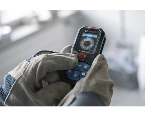 Bosch Professional laseravståndsmätare som används av händer i arbetshandskar, digital display med mätfunktioner.
