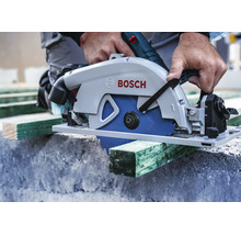 Hantverkare sågar en träplanka med en Bosch handhållen cirkelsåg på en byggarbetsplats.