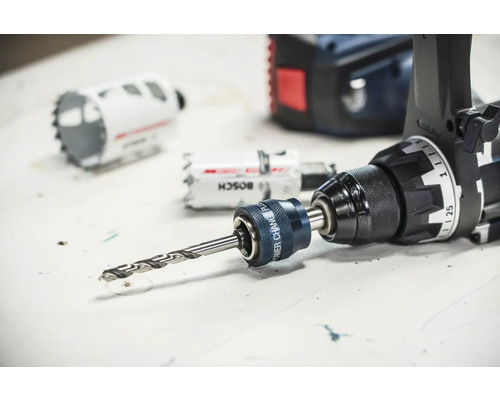 Bosch Power Change Plus-adapter med centrumborr monterad på en borrskruvdragare bredvid hålsågar.
