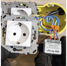 Installation av en Shelly EM Mini Gen4 energimätare bakom ett vägguttag.
