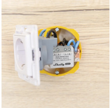 Shelly EM Mini Generation 4 energimätare installerad i en infälld dosa bakom ett eluttag.