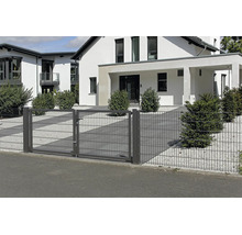 Tvåfliglad trädgårdsgrind av dubbelpanelsstängsel i antracit framför ett modernt bostadshus med grusträdgård.