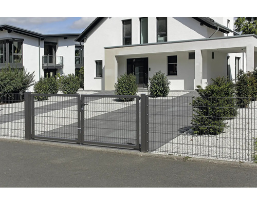 Tvåfliglad trädgårdsgrind av dubbelpanelsstängsel i antracit framför ett modernt bostadshus med grusträdgård.