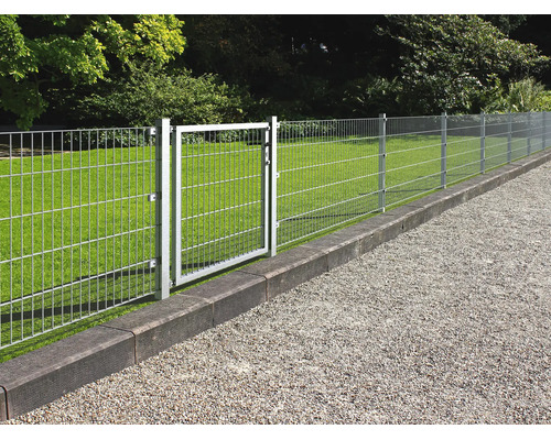 Galvaniserat panelstängsel med matchande trädgårdsgrind på en gräsmatta intill en grusgång.