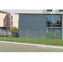 Dubbelpanelstängsel av metall på en gräsmatta framför en modern byggnad.