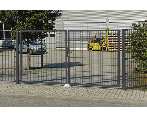 Dubbel infartsgrind av dubbelpanelsnät på ett industriområde med en skåpbil och en gaffeltruck i bakgrunden.