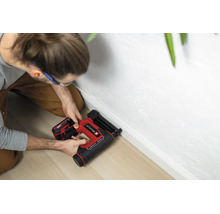 Einhell sladdlös dyckertpistol vid montering av en vit golvlist på ett ljust trägolv.