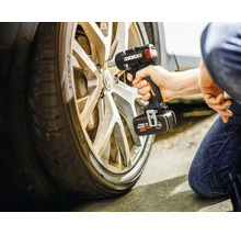 En person knäböjer vid ett däck och använder en Worx batteridriven mutterdragare med 20 Volt batteri för att lossa hjulmuttrar på en metallfälg.
