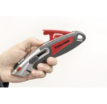 Hand som håller en Rautner säkerhetskniv med infällbart blad och ergonomiskt handtag.