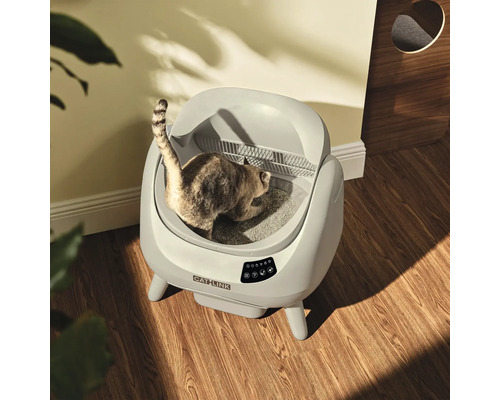 Självrengörande Catlink kattlåda på trägolv med en katt i ett ljust rum.