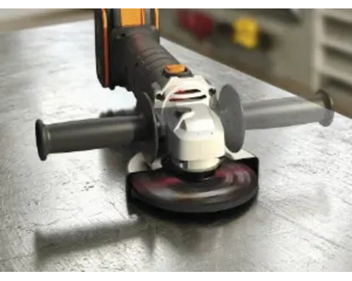 Batteridriven vinkelslip med sidohandtag och slipskiva på en arbetsyta av metall.