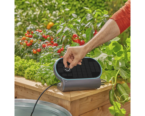 Gardena bevattningsstyrning för pallkragar med solpanel och vridknapp för enkel användning i en trädgårdsmiljö.