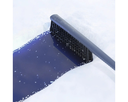 Kungs snöborste med integrerad isskrapa som tar bort snö från en fordonsyta.