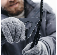 En person med handskar använder en torkarbladsrengörare för att avgrada och rengöra ett torkarblad under vintern.