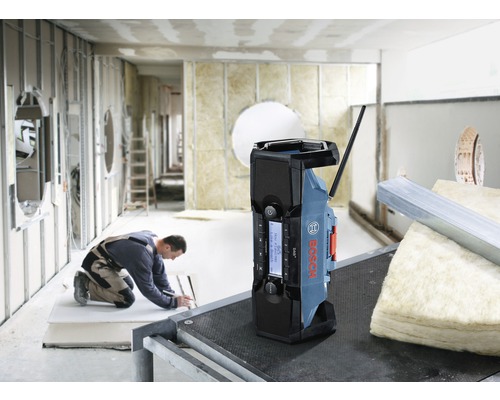 Byggradio från Bosch på en byggarbetsplats, en arbetare i bakgrunden.