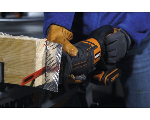 En person sågar en träbit med metallbeklädnad med en oscillerande såg. Verktyget är från Worx.